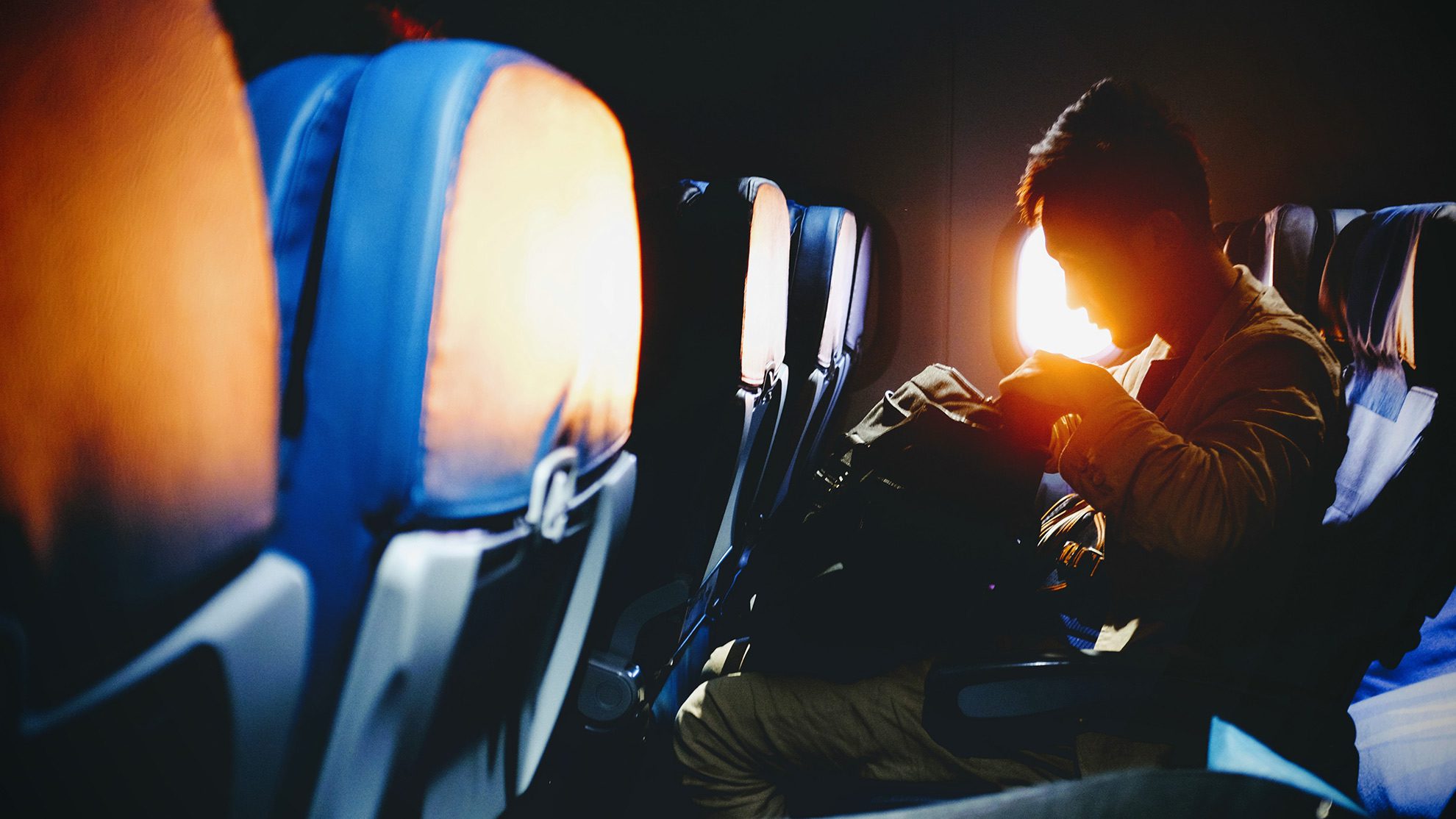 Человек проверяет сумку в самолете