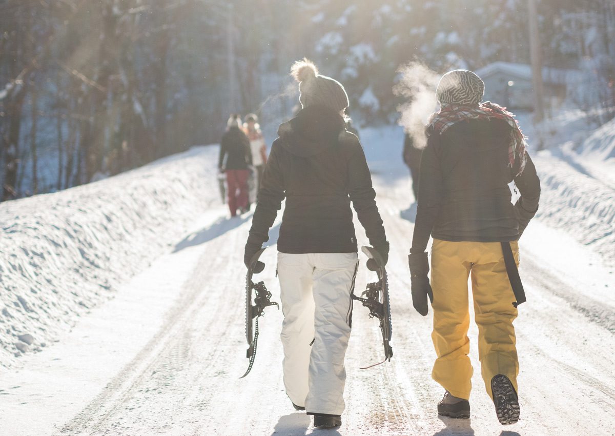 Люди с лыжами идут в гору