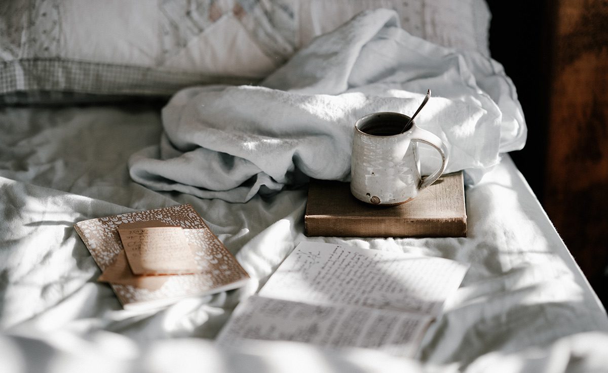 Кружка кофе и книжка на кровати