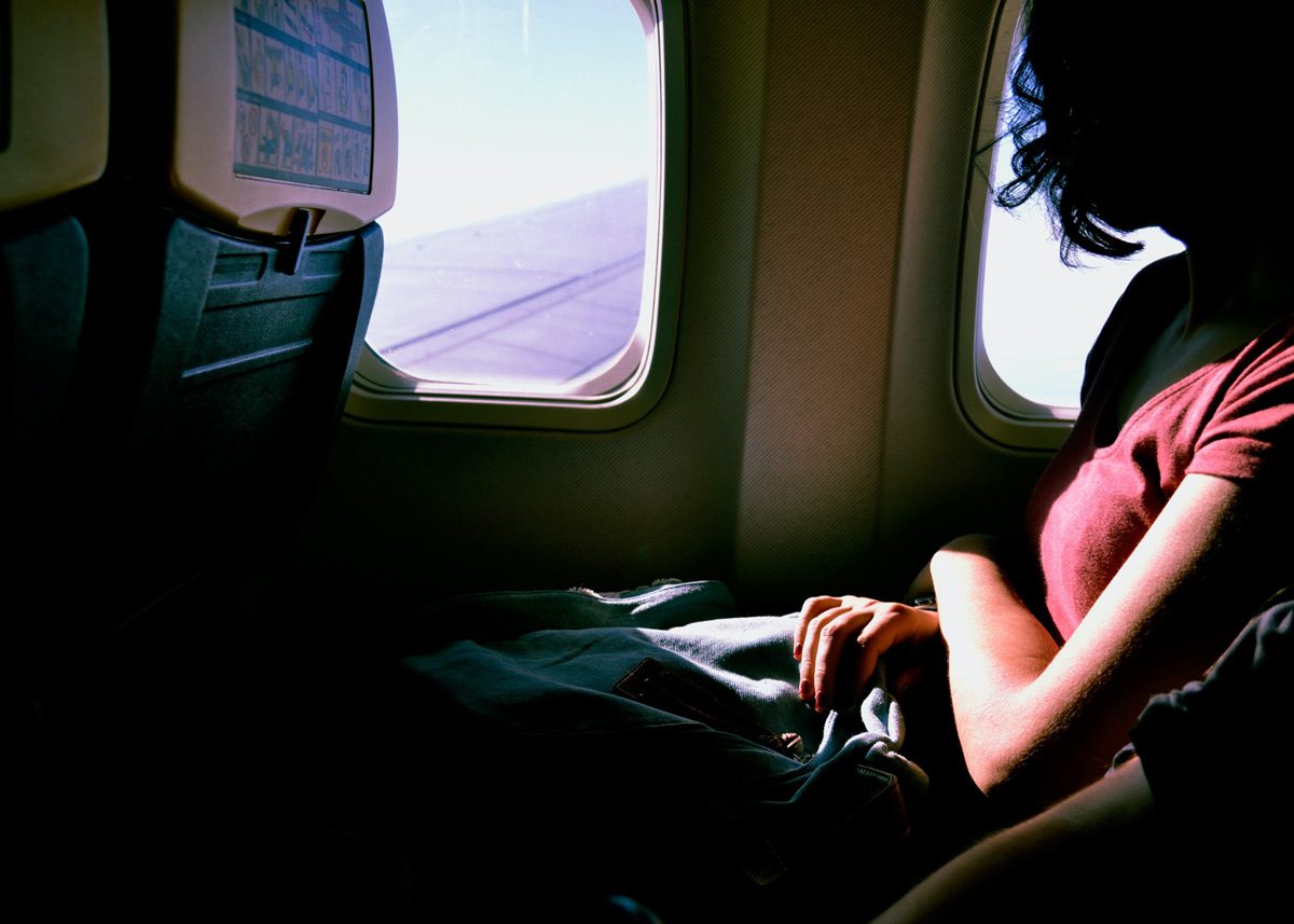 Девушка смотрит в иллюминатор самолёта