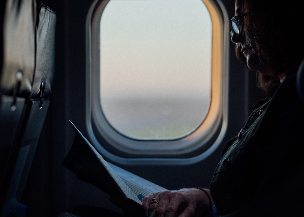 Женщина читает журнал в самолёте