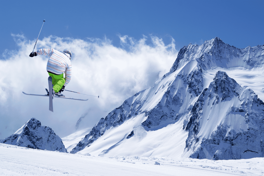 Лыжник в зеленых штанах скатывается с горы